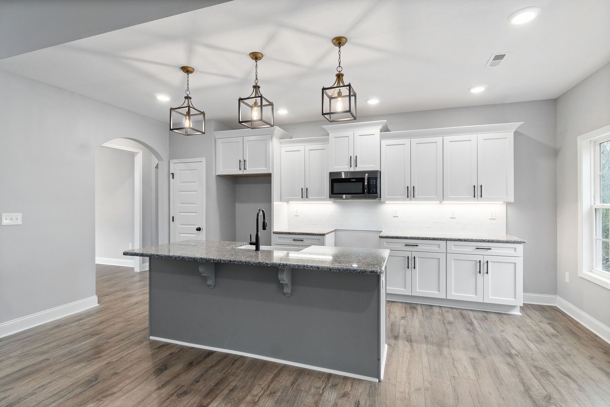 2790 Russell Road Palmyra, TN 37142 - Photo 8 of 31 a kitchen with kitchen island granite countertop a sink cabinets and wooden floor
