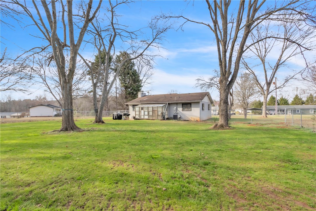 139 Louise Drive Pendleton, SC 29670 - Photo 23 of 26 Expansive green grounds surround this charming home, offering ample outdoor living space and mature trees.