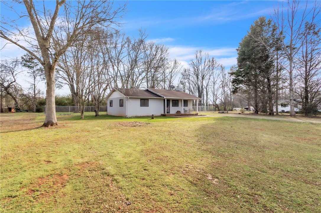 139 Louise Drive Pendleton, SC 29670 - Photo 26 of 26 A charming residence surrounded by lush greenery, offering a peaceful and private outdoor experience.