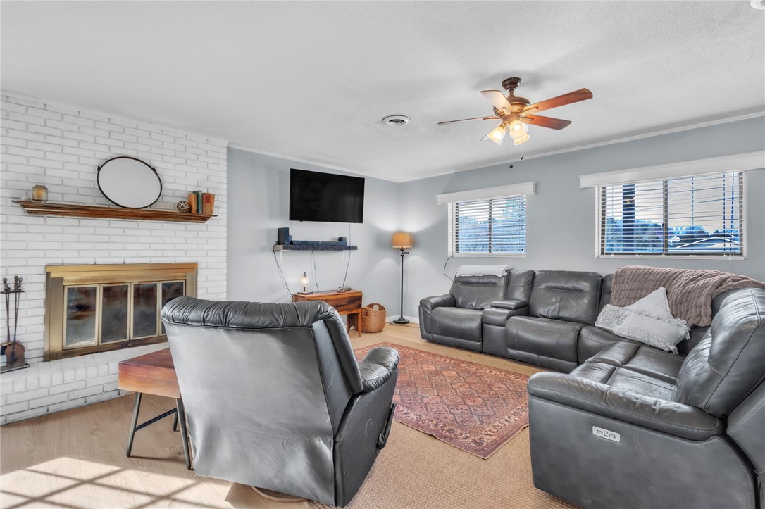 139 Louise Drive Pendleton, SC 29670 - Photo 7 of 26 Bright and airy living area featuring a cozy fireplace and expansive windows.