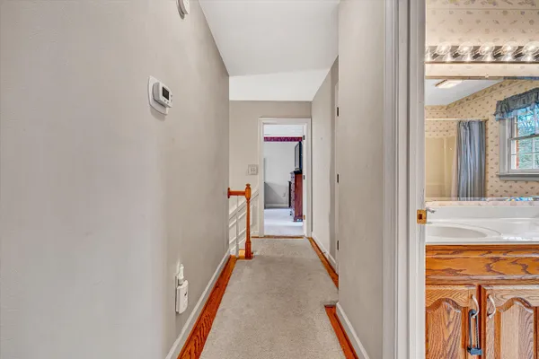 a view of a hallway with wooden floor and staircase