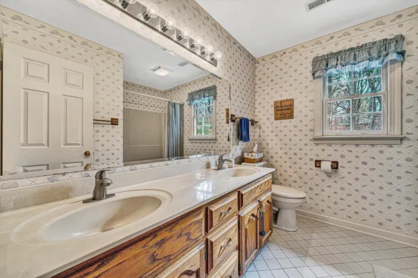 a bathroom with a double vanity sink toilet and a mirror