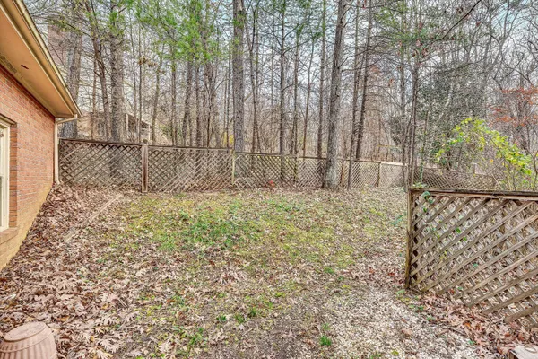 a view of backyard with wooden fence