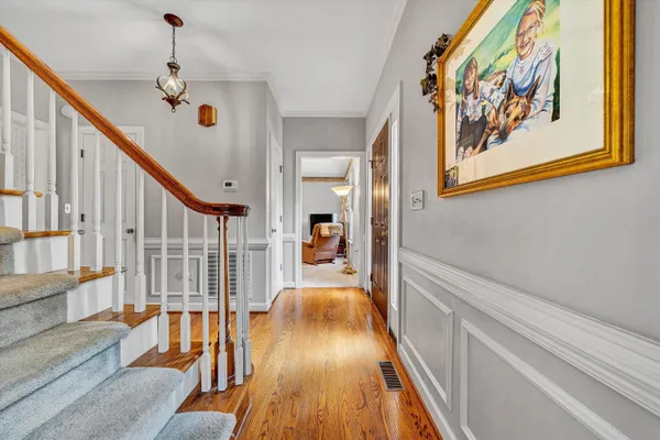 a view of a hallway with wooden floor and staircase