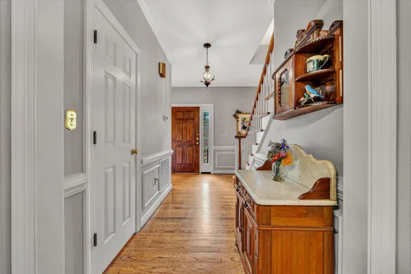 a hallway view with staircase and wooden floors