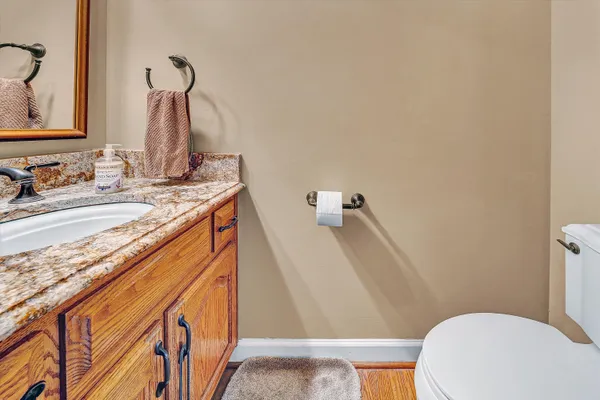 a bathroom with a granite countertop sink a toilet and a mirror