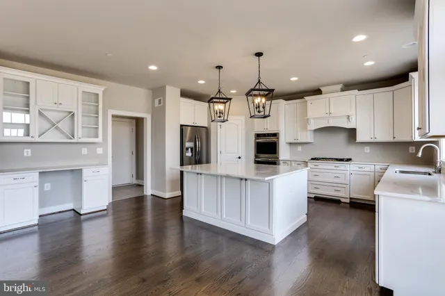 a kitchen with stainless steel appliances white cabinets and a refrigerator