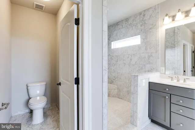 a bathroom with a granite countertop bathtub a sink and a large mirror