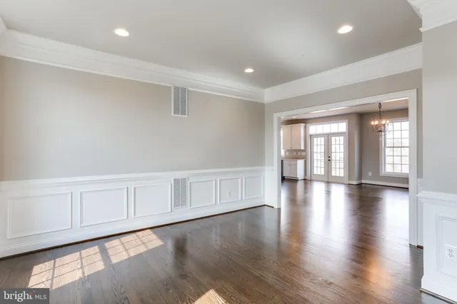 an empty room with wooden floor and a fireplace