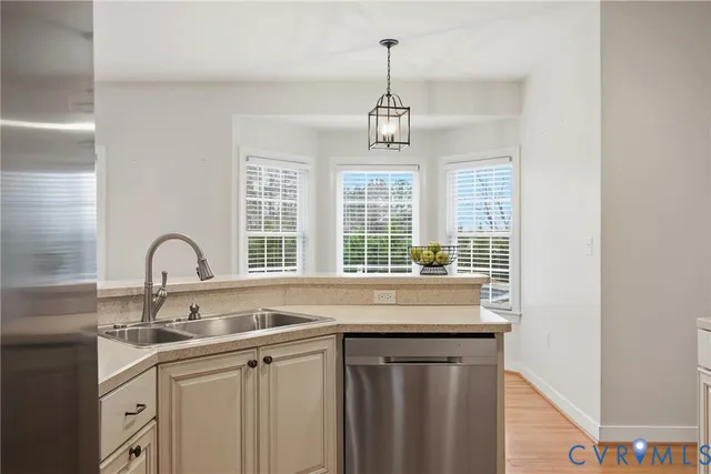 a view of an empty room with wooden floor fireplace and a window