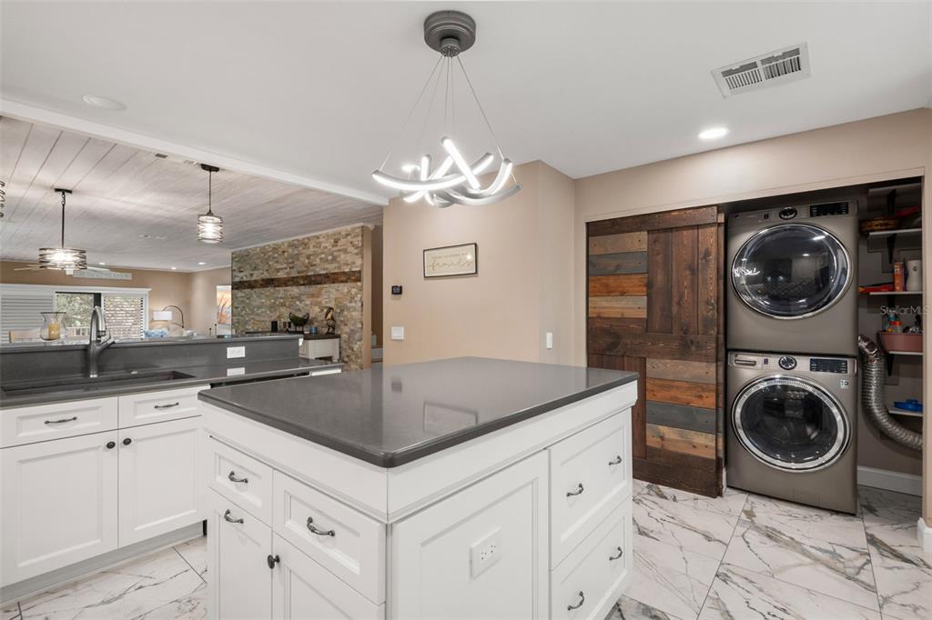 529 Sandy Hook Road Treasure Island, FL 33706 - Photo 17 of 55 a kitchen with granite countertop a sink a stove and a wooden floors