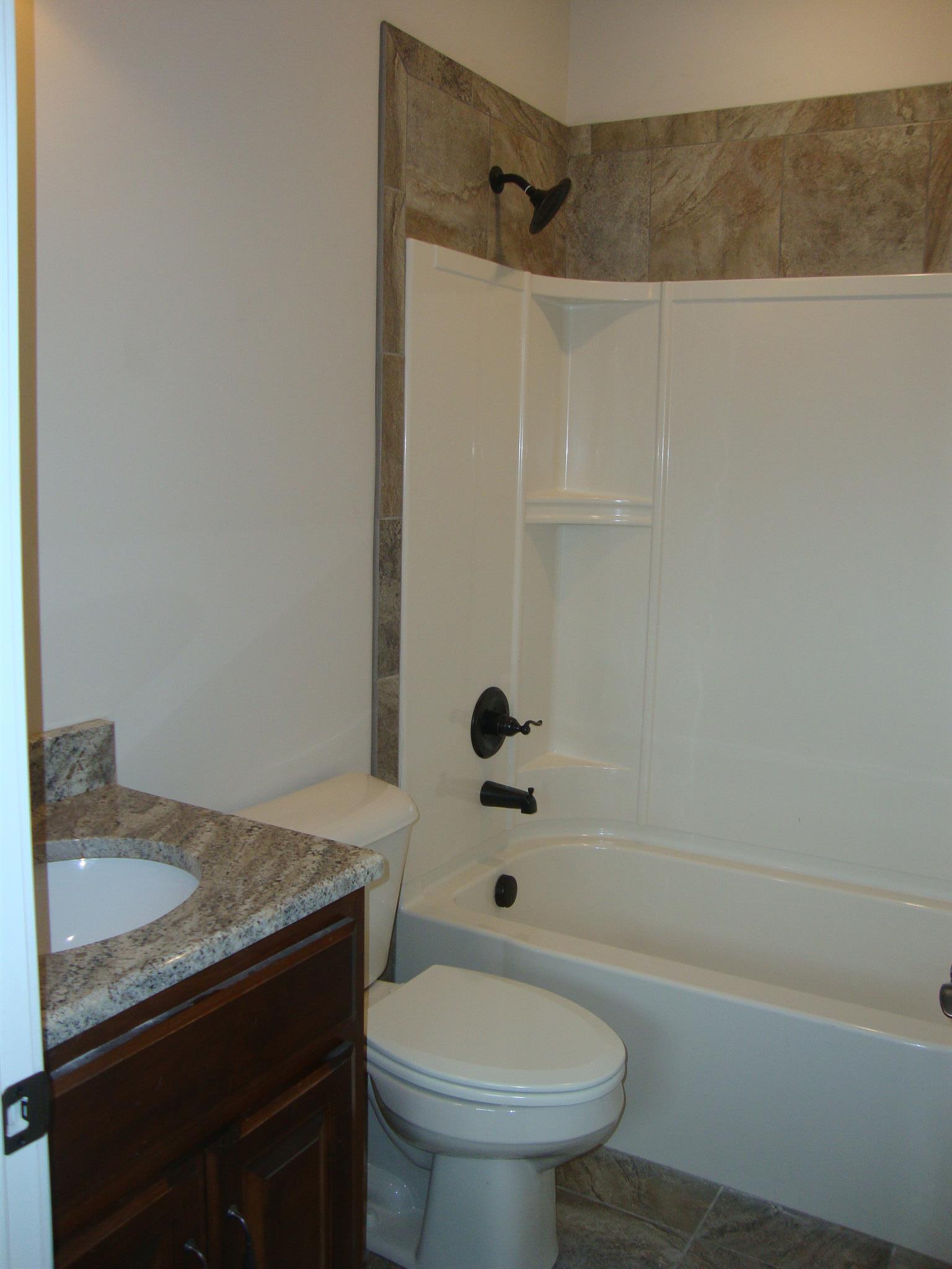 3596 Drake Road Adams, TN 37010 - Photo 15 of 25 a bathroom with a granite countertop sink toilet and shower