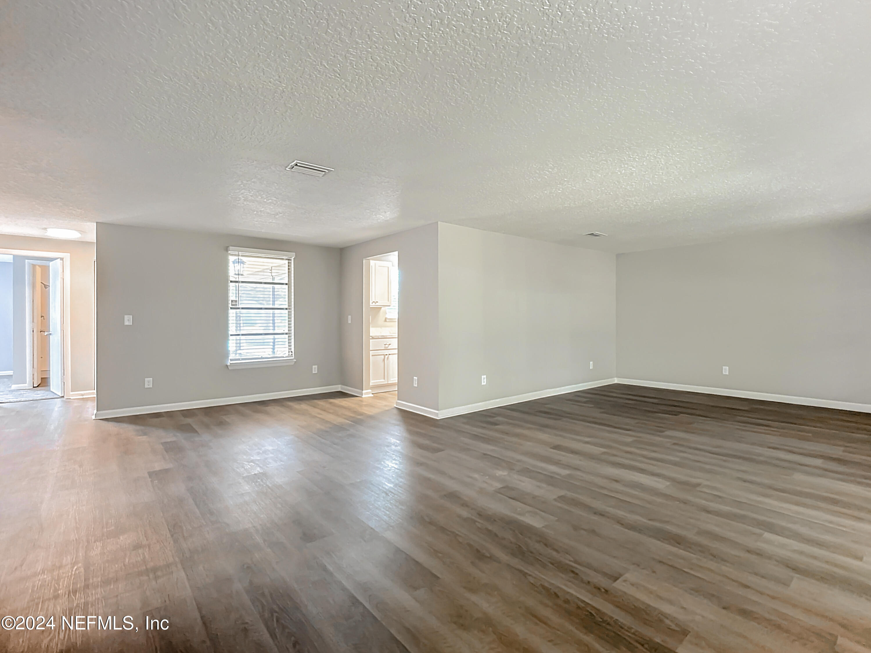 242 Shores Boulevard St. Augustine, FL 32086 - Photo 11 of 42 an empty room with wooden floor and windows