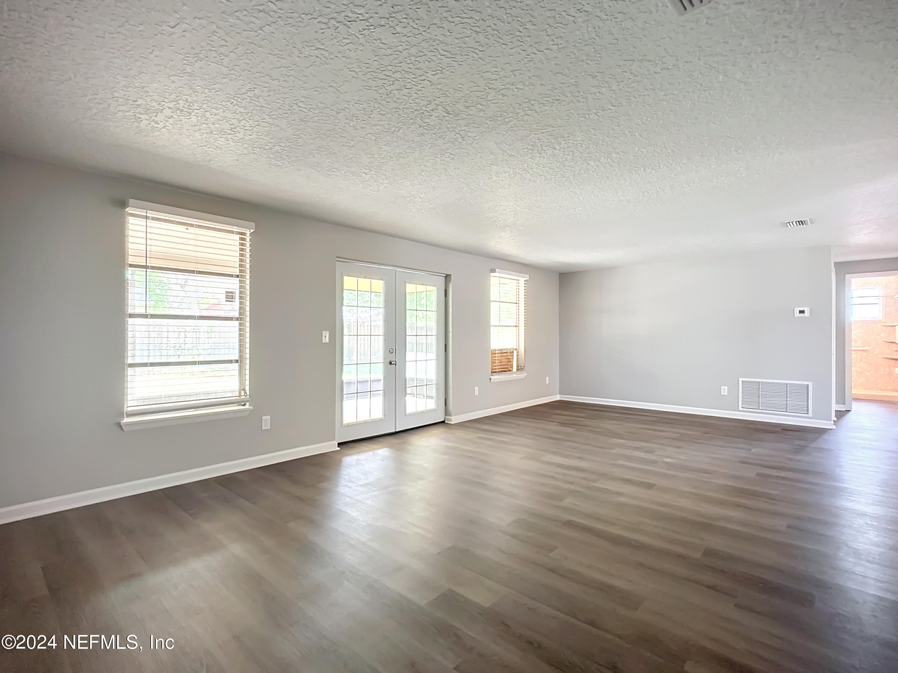 242 Shores Boulevard St. Augustine, FL 32086 - Photo 13 of 42 an empty room with wooden floor and windows