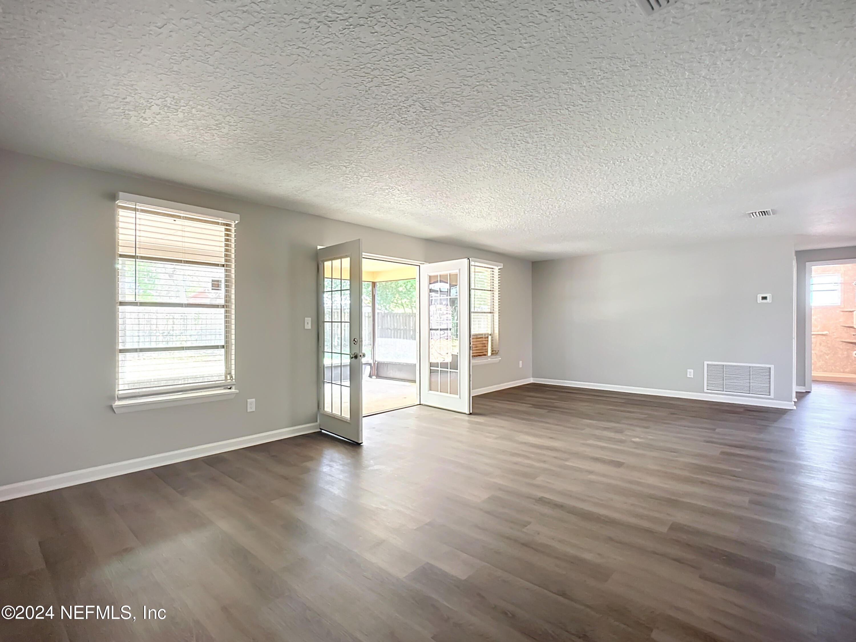 242 Shores Boulevard St. Augustine, FL 32086 - Photo 14 of 42 an empty room with wooden floor and windows
