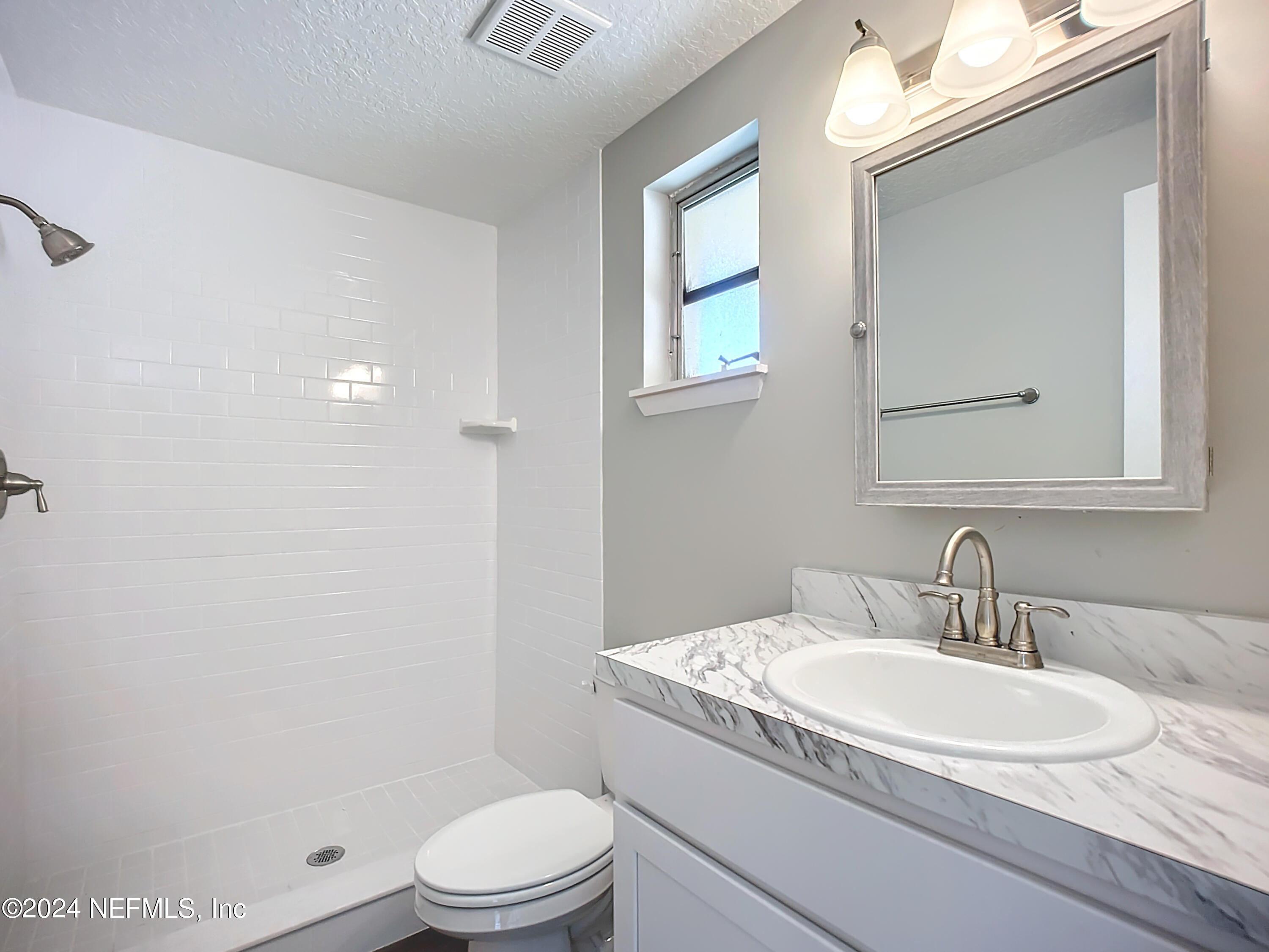 242 Shores Boulevard St. Augustine, FL 32086 - Photo 18 of 42 a bathroom with a granite countertop sink toilet a mirror and shower