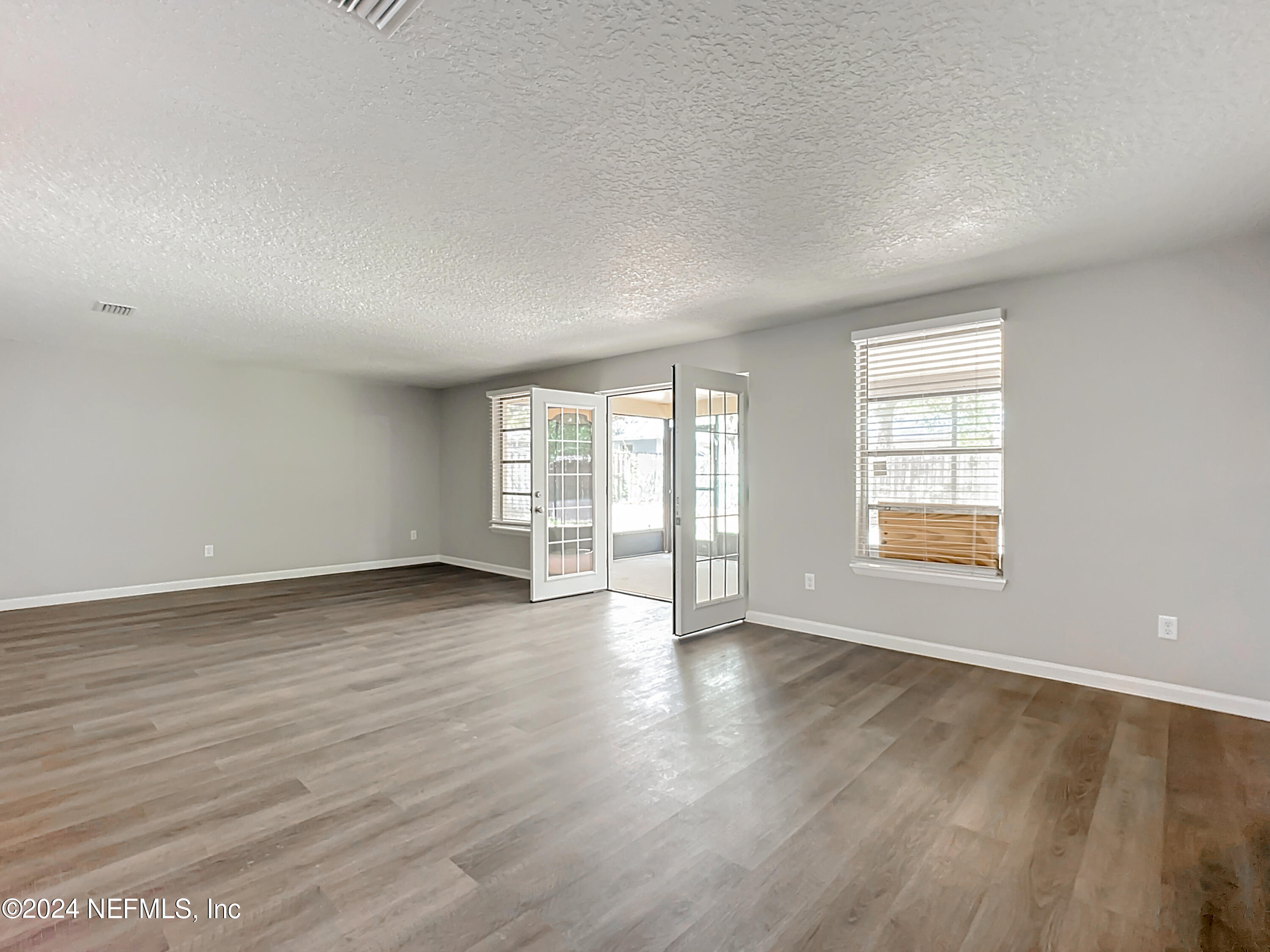 242 Shores Boulevard St. Augustine, FL 32086 - Photo 10 of 42 an empty room with wooden floor and windows