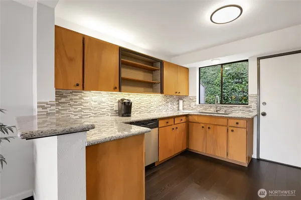 a kitchen with granite countertop cabinets sink and window