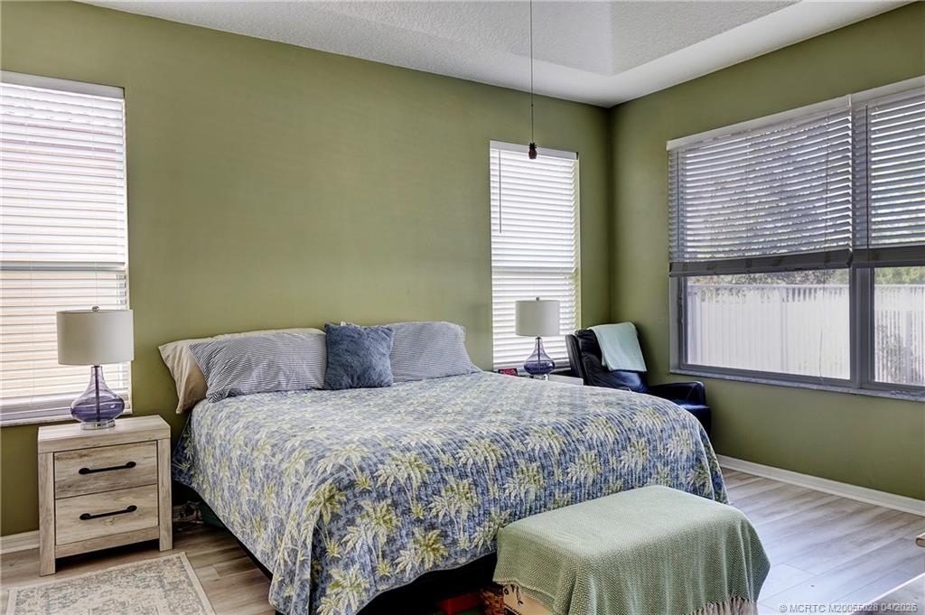 2120 Northwest Marsh Rabbit Lane Jensen Beach, FL 34957 - Photo 19 of 34 a bedroom with a bed and windows
