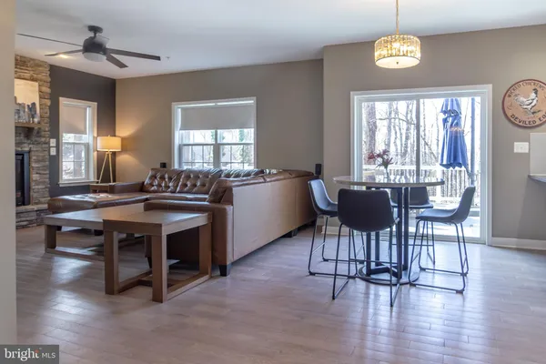 a open dining room with furniture a chandelier and wooden floor