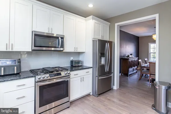 a kitchen with stainless steel appliances granite countertop a stove a refrigerator and a microwave