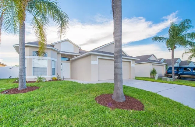a front view of a house with a garden and yard