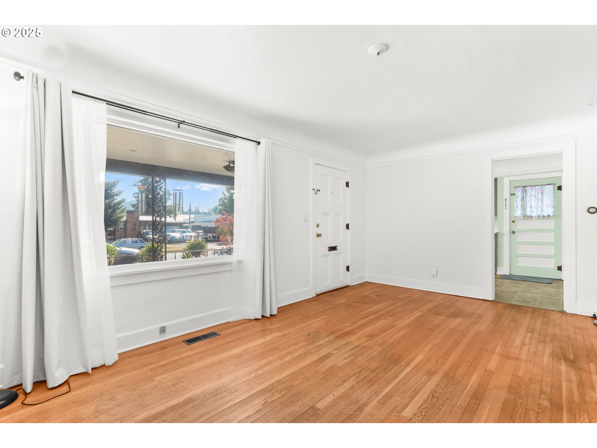 8233 Northeast Tillamook Street Portland, OR 97220 - Photo 11 of 46 a view of an empty room with wooden floor and a window