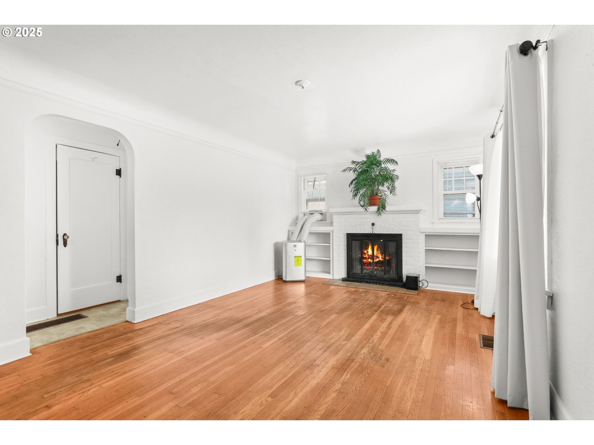 8233 Northeast Tillamook Street Portland, OR 97220 - Photo 8 of 46 a view of an empty room with a fireplace and window