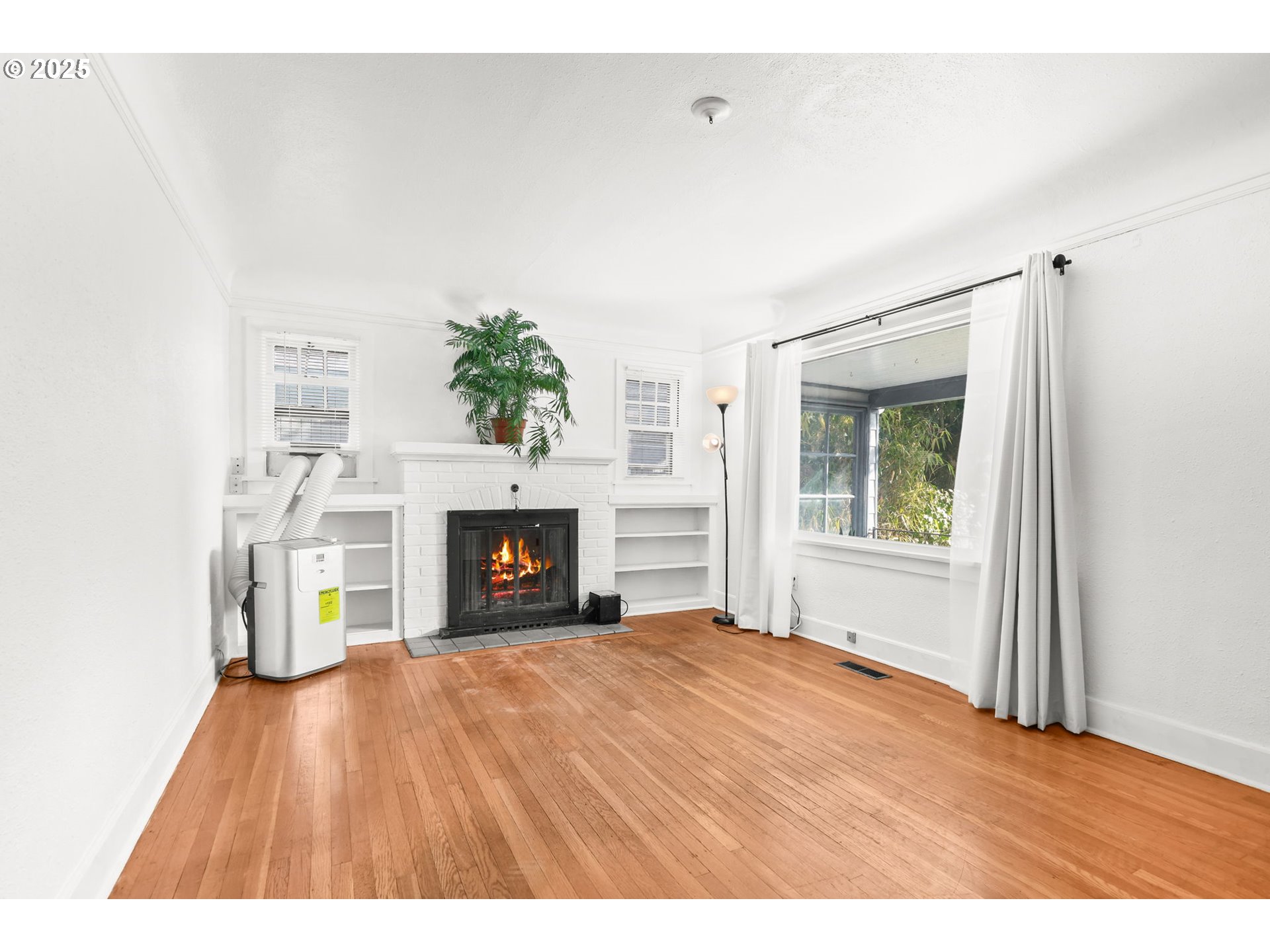 8233 Northeast Tillamook Street Portland, OR 97220 - Photo 9 of 46 a view of an empty room with a fireplace and a window