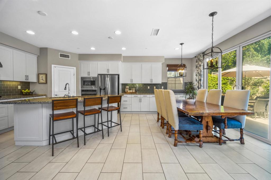 7351 Circulo Ronda Carlsbad, CA 92009 - Photo 13 of 37 a living room with stainless steel appliances kitchen island granite countertop furniture and a view of dining table