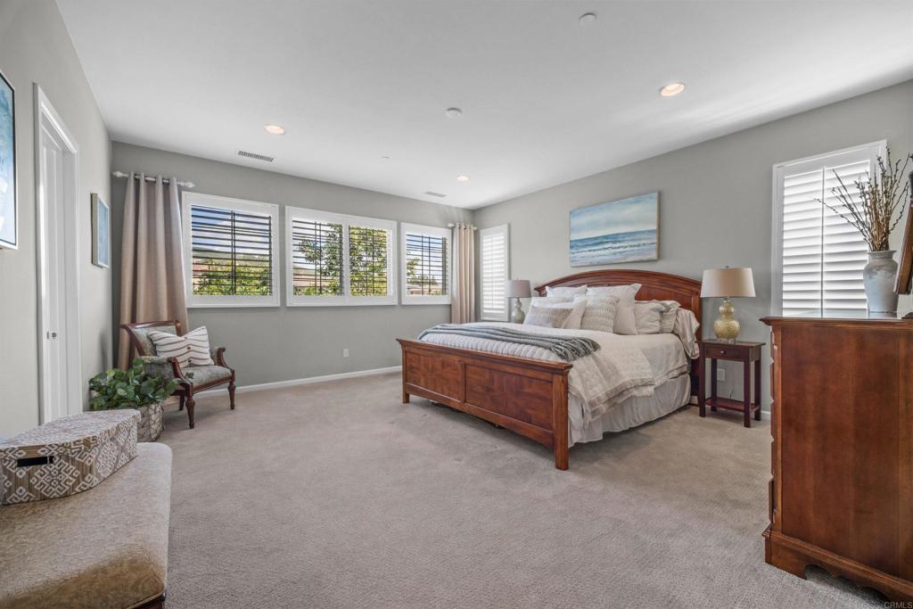 7351 Circulo Ronda Carlsbad, CA 92009 - Photo 21 of 37 a spacious bedroom with a bed and a couch