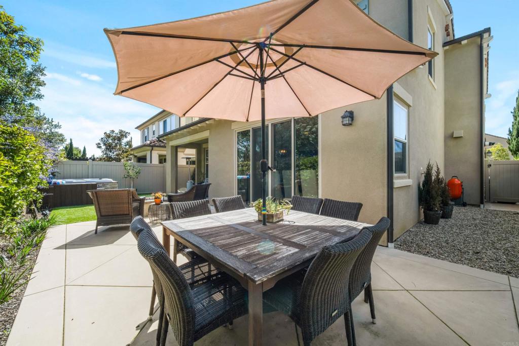 7351 Circulo Ronda Carlsbad, CA 92009 - Photo 33 of 37 a patio with a table and chairs under an umbrella
