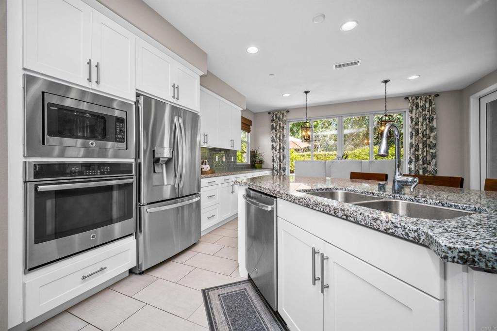 7351 Circulo Ronda Carlsbad, CA 92009 - Photo 10 of 37 a kitchen with stainless steel appliances granite countertop a stove a sink and a refrigerator