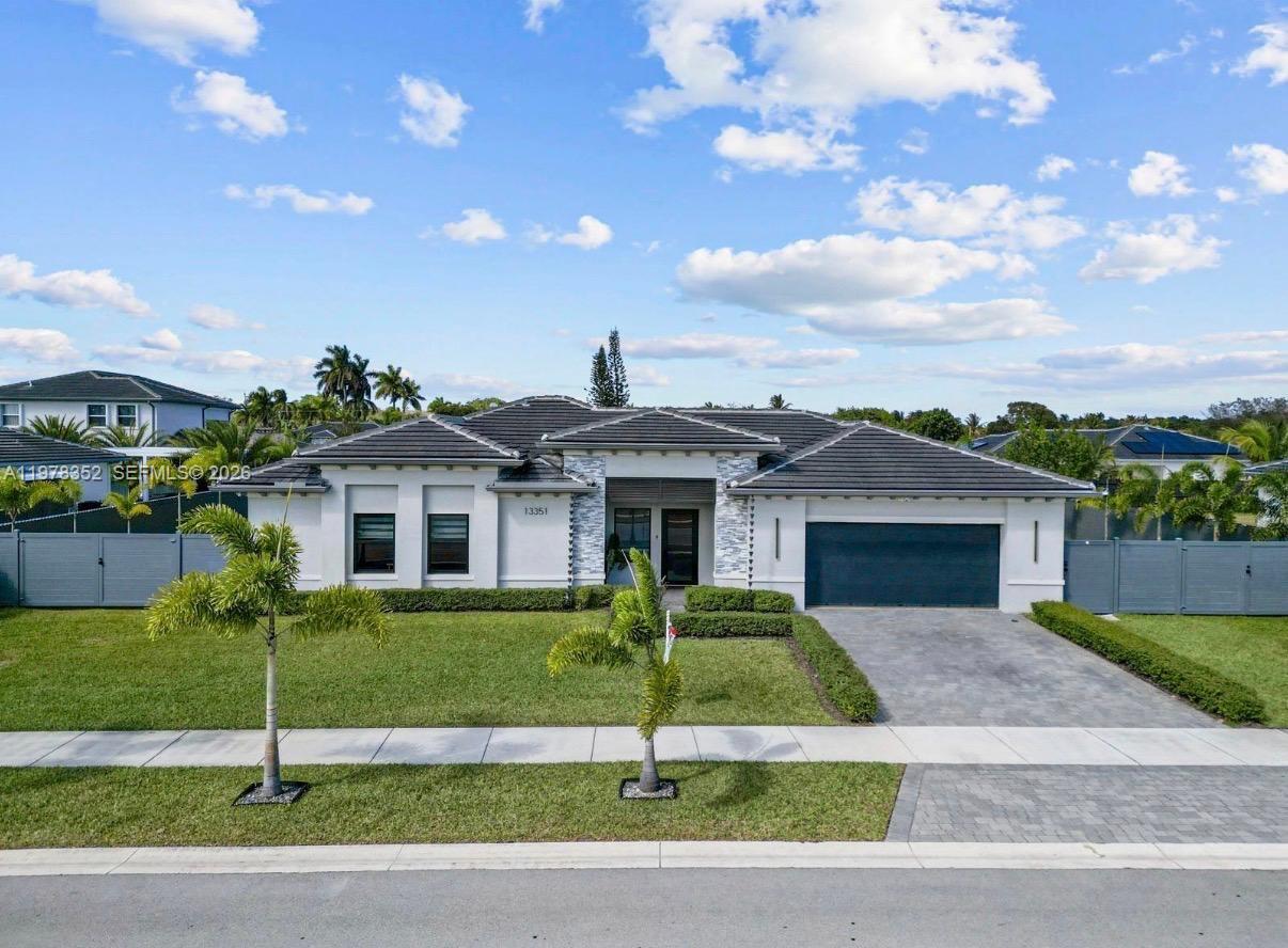 13351 Southwest 190th Street Miami, FL 33177 - Photo 1 of 45 a front view of a house with a garden