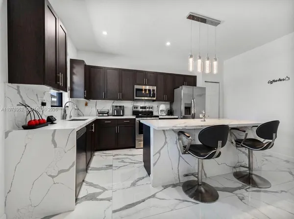 a kitchen with stainless steel appliances a stove microwave and sink