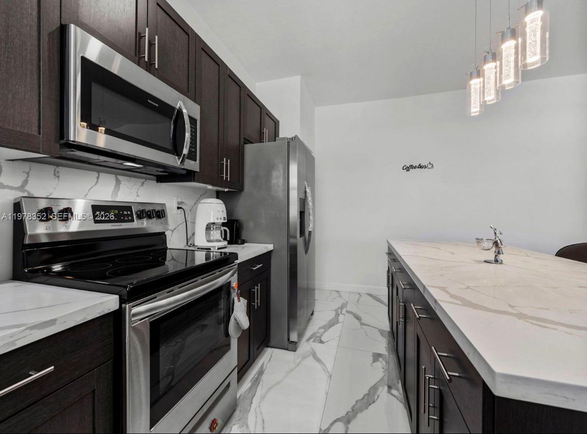 13351 Southwest 190th Street Miami, FL 33177 - Photo 15 of 45 a kitchen with stainless steel appliances a stove microwave and sink