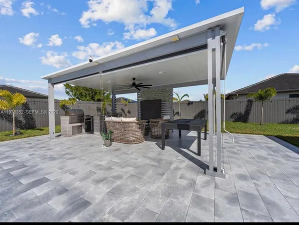 a view of a house with backyard and sitting area