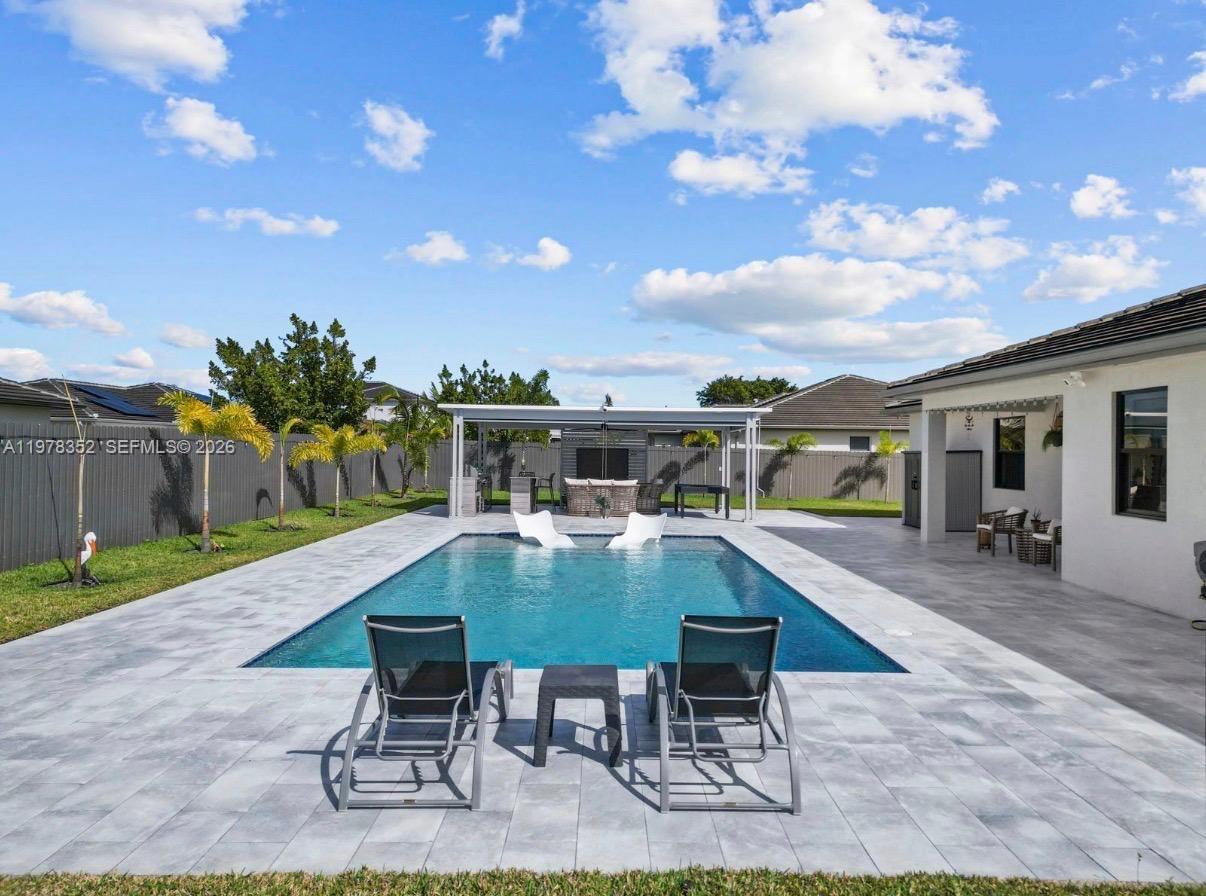 13351 Southwest 190th Street Miami, FL 33177 - Photo 40 of 45 a swimming pool with outdoor seating and yard in back