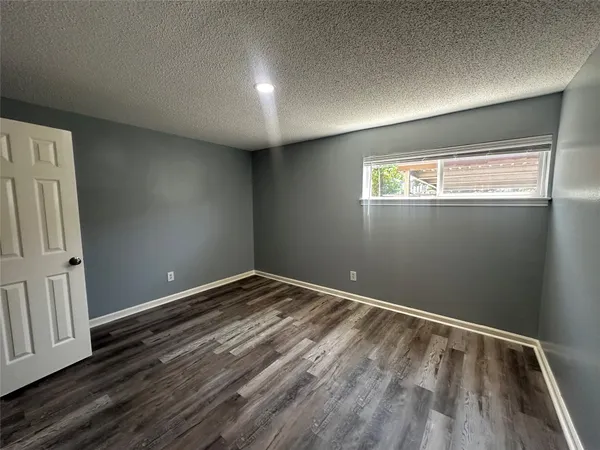 a view of empty room with wooden floor