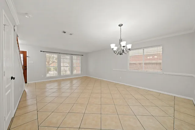a view of a livingroom with wooden floor a ceiling fan and windows