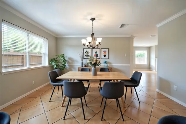 a dining room with furniture a chandelier and window