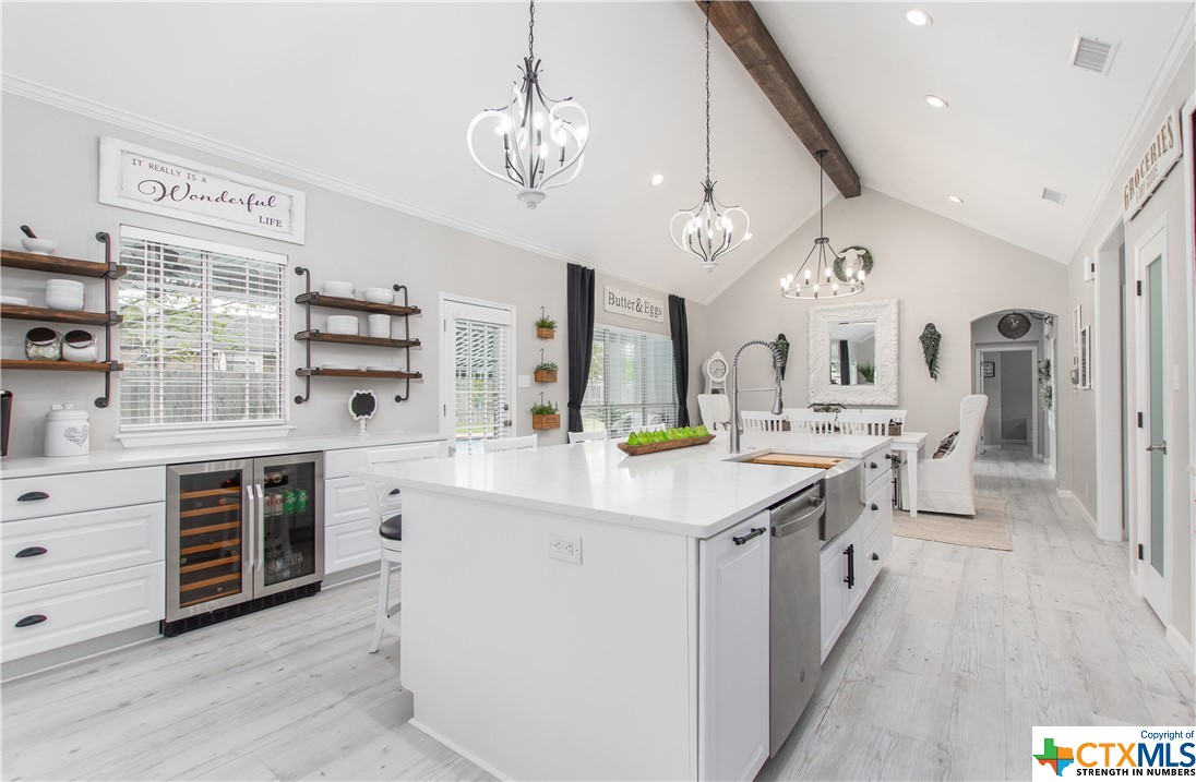 a kitchen with kitchen island granite countertop a sink cabinets and wooden floor