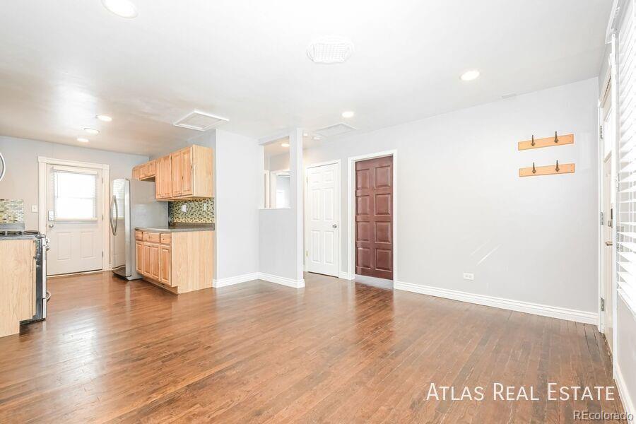 661 Stuart Street Denver, CO 80204 - Photo 2 of 18 a view of a kitchen with a refrigerator and wooden floor