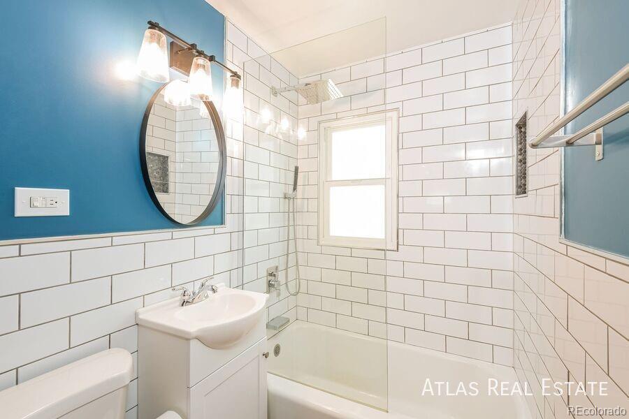 661 Stuart Street Denver, CO 80204 - Photo 4 of 18 a bathroom with a sink a mirror and a shower