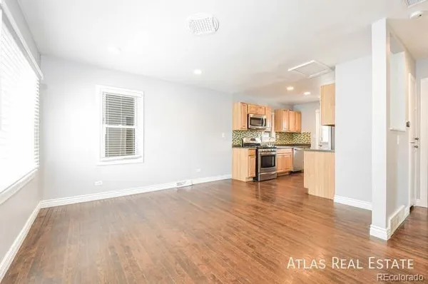 a view of a kitchen with a sink stove cabinets and empty room