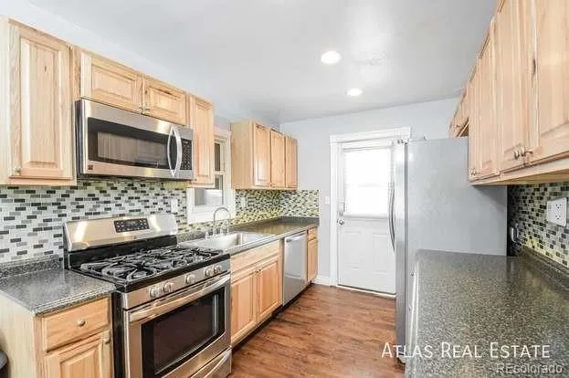 a kitchen with stainless steel appliances granite countertop a stove a sink and a microwave