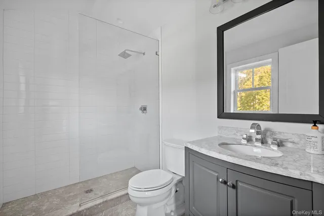 a bathroom with a granite countertop sink toilet and a mirror