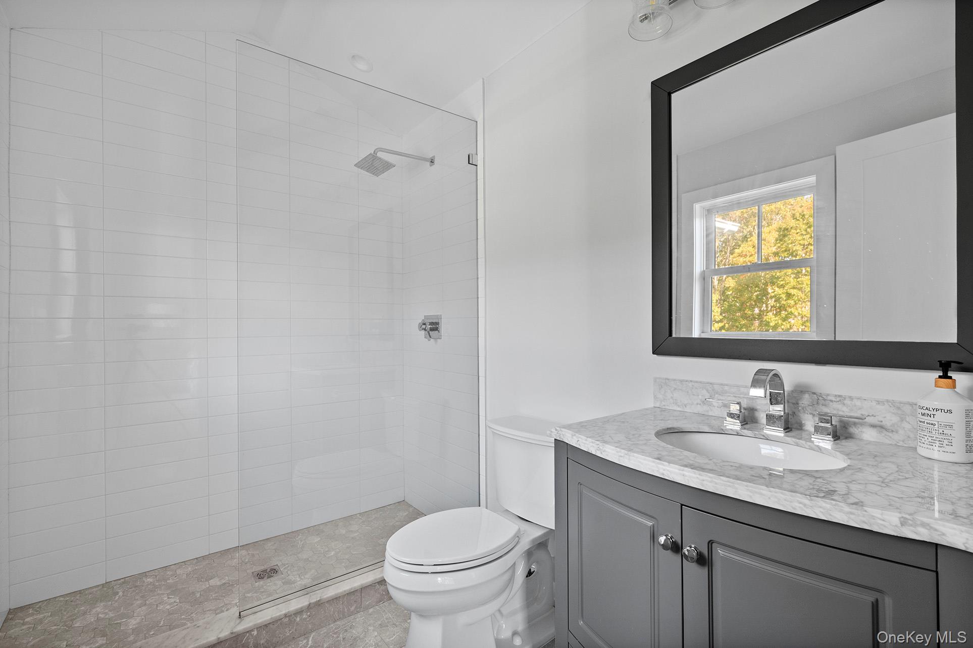 41 Arbutus Road Quogue, NY 11959 - Photo 25 of 35 a bathroom with a granite countertop sink toilet and a mirror
