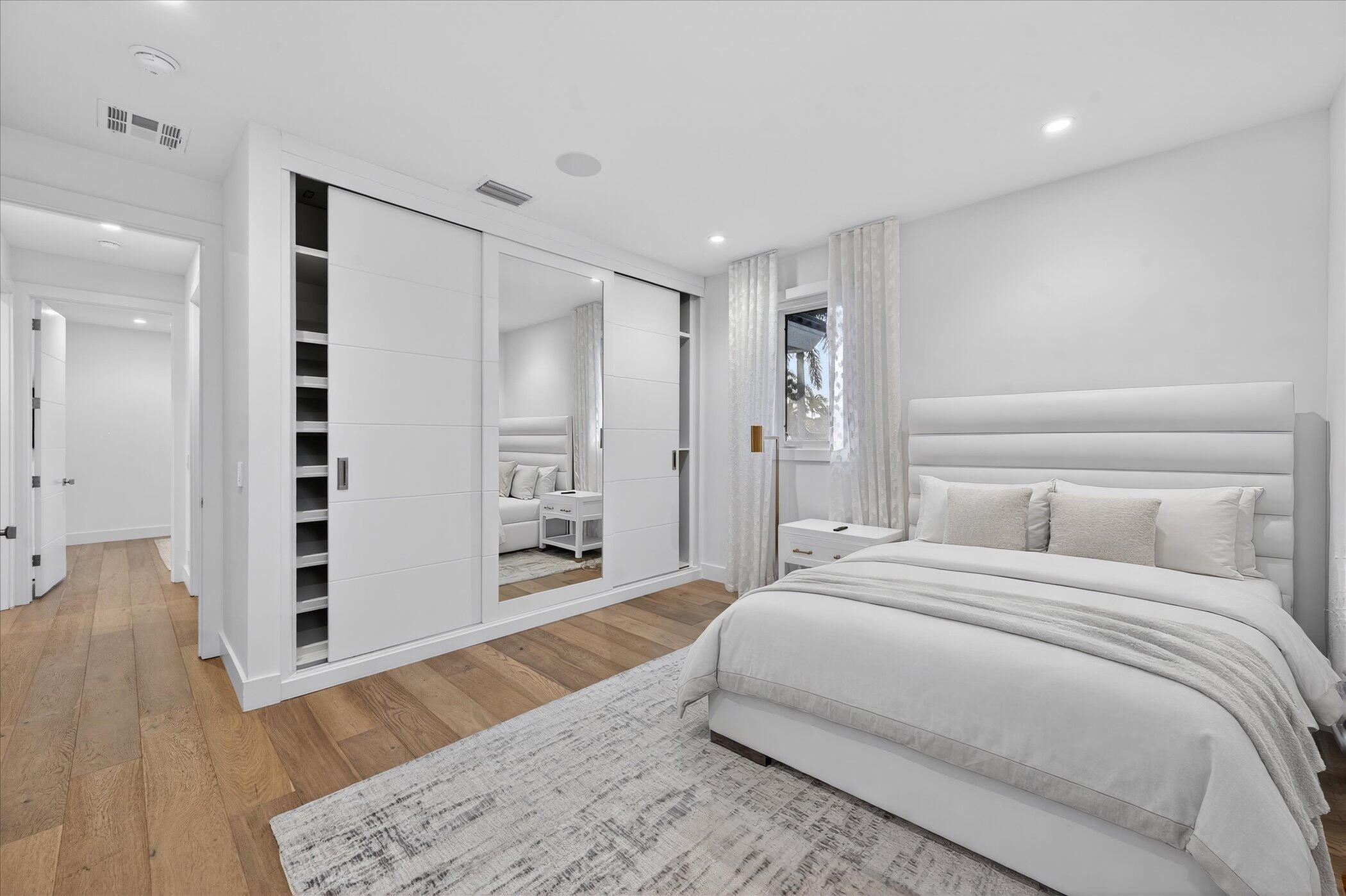 3872 Northwest 53rd Street Boca Raton, FL 33496 - Photo 31 of 43 a spacious bedroom with a bed and a wooden floor