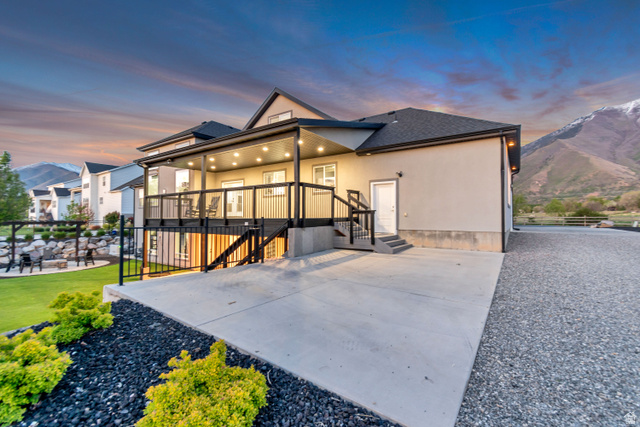 1526 South 500 West Mapleton, UT 84664 - Photo 39 of 54 Back of property at dusk featuring stucco siding, a shingled roof, and a mountain view